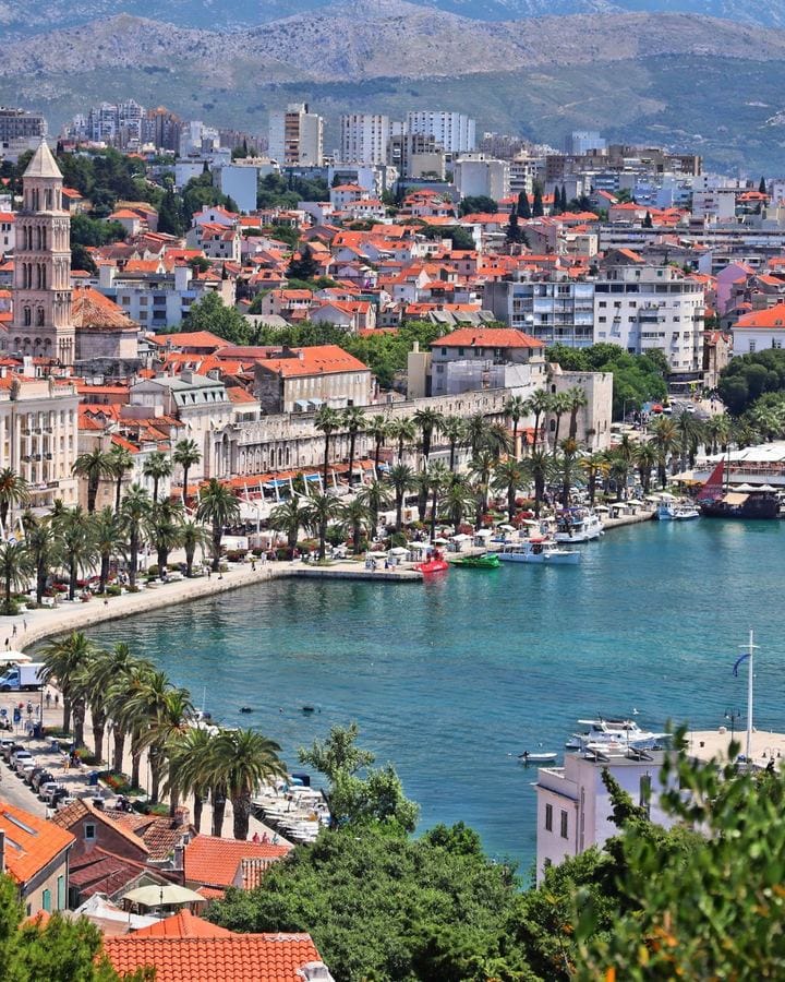 Split's palm-lined Riva waterfront and cathedral bell tower beside the turquoise bay